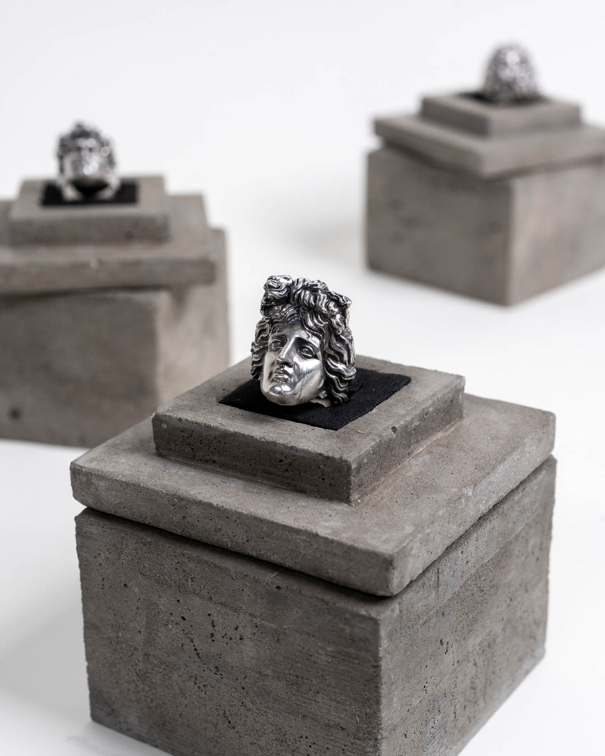 Apollon Ring Sterling Silver on top of its concrete package