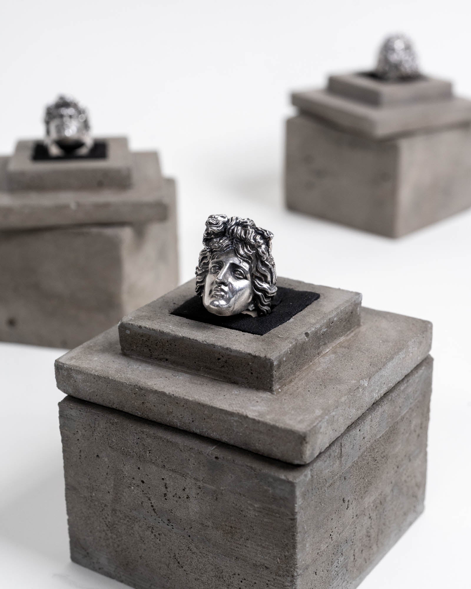 Apollon Ring Sterling Silver on top of its concrete package