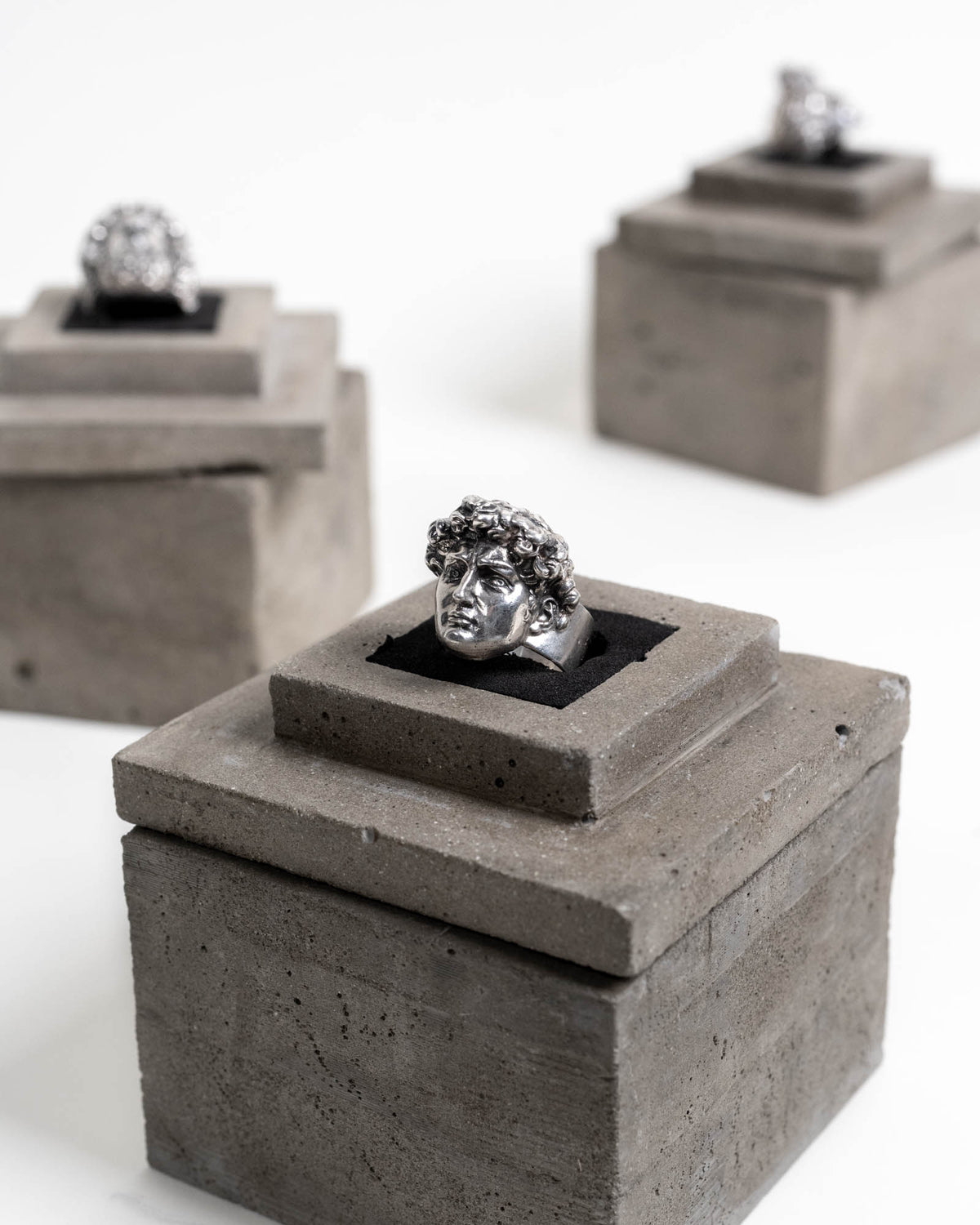 Michelangelo's David Ring Sterling Silver on top of its concrete packaging