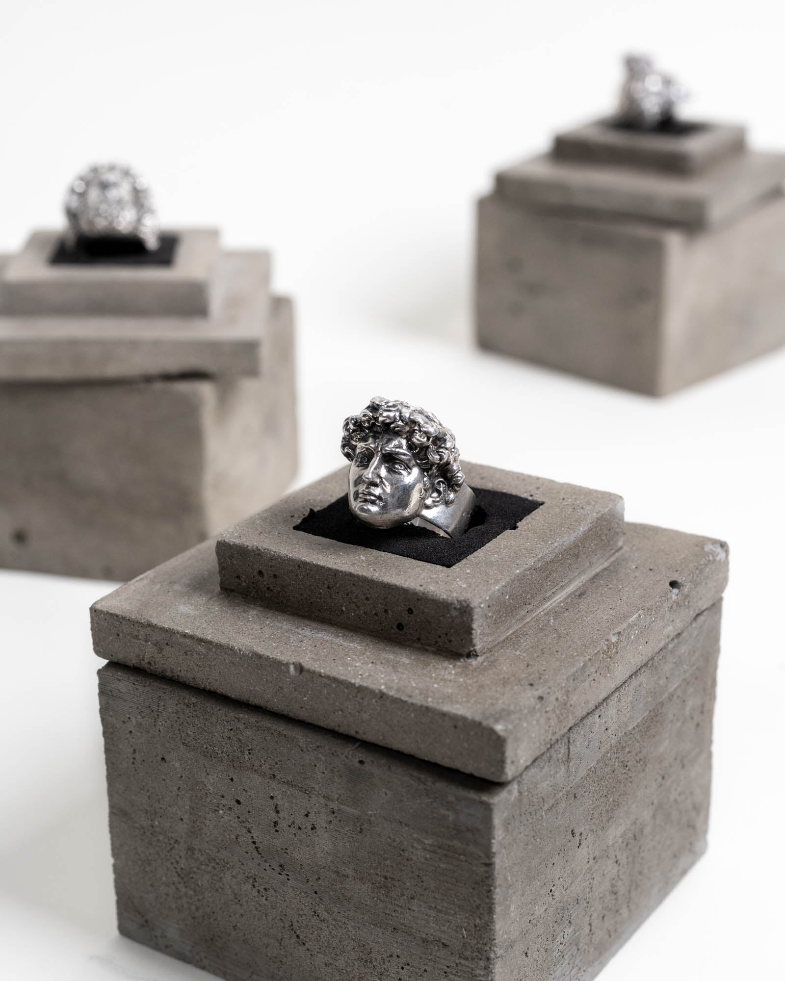 Michelangelo's David Ring Sterling Silver on top of its concrete packaging